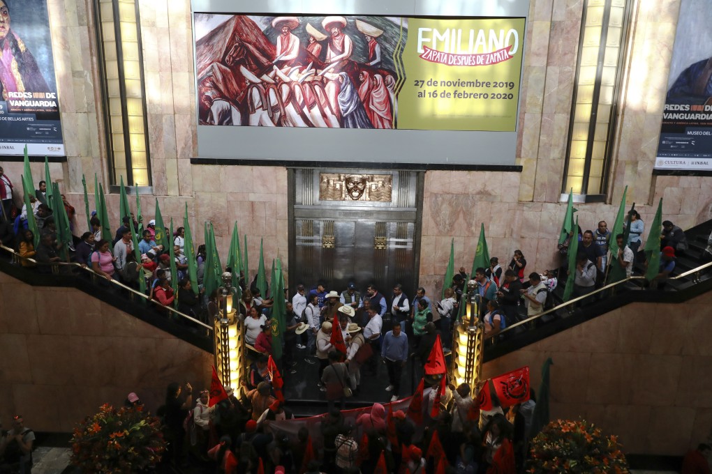 Protesting farm workers block the entrance to a museum exhibiting a painting showing a nude Emiliano Zapata straddling a horse in high heels and a pink sombrero, in Mexico City on December 10. Photo: AP