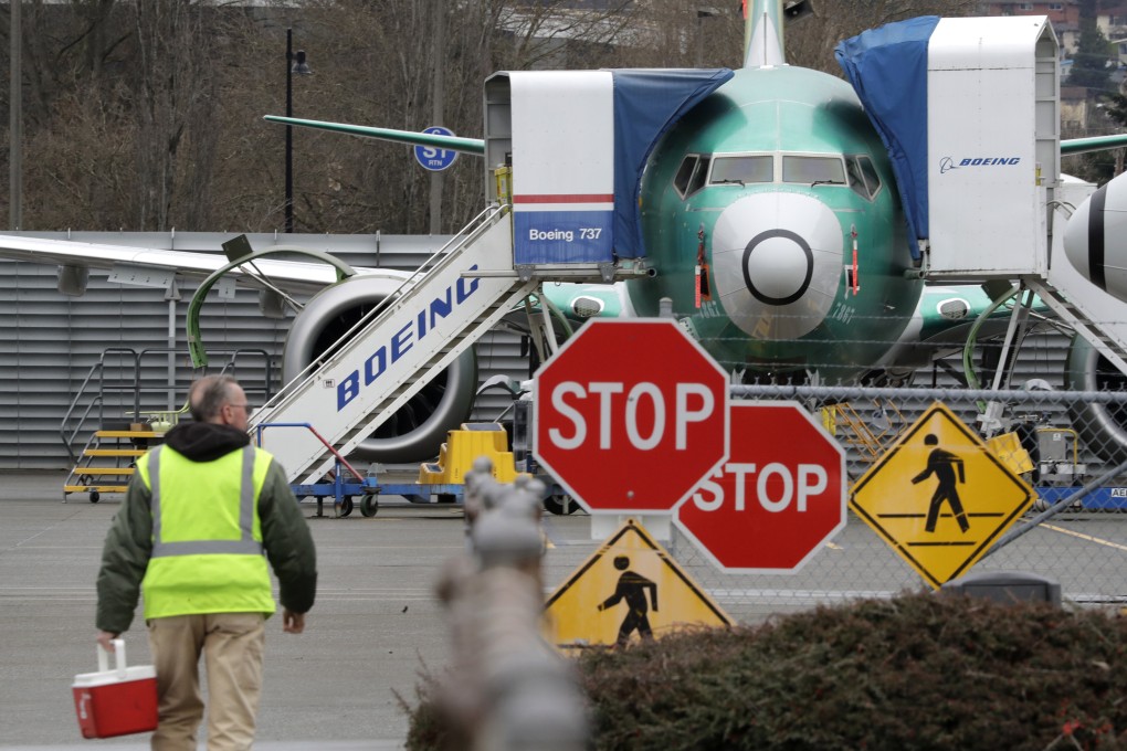 A Boeing worker walks in view of a 737 MAX aircraft in Renton, Washington, on Monday. Photo: AP
