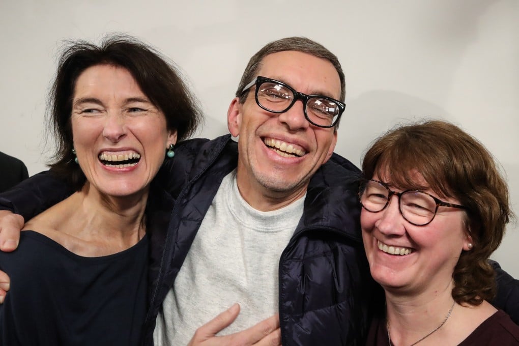 Jens Soering, centre, celebrates with supporters after landing in Frankfurt. Photo: EPA