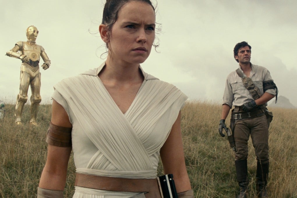 From left: D-O, Rey (Daisy Ridley), and Poe Dameron (Oscar Isaac) in a still from Star Wars: The Rise of Skywalker (category:), directed by J.J. Abrams. Adam Driver and John Boyega co-star.