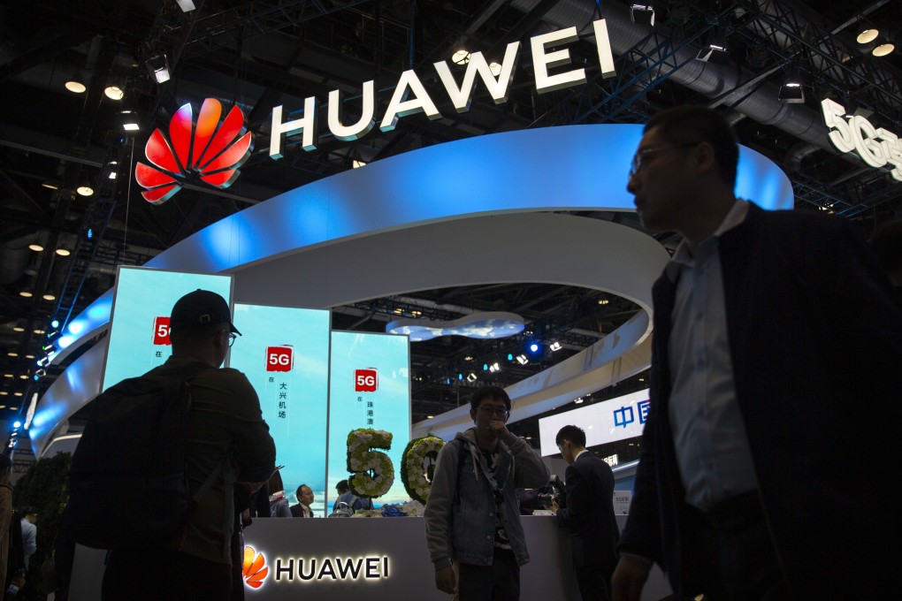 Attendees walk past a display for 5G services from Huawei at the PT Expo in Beijing in October. Photo: AP