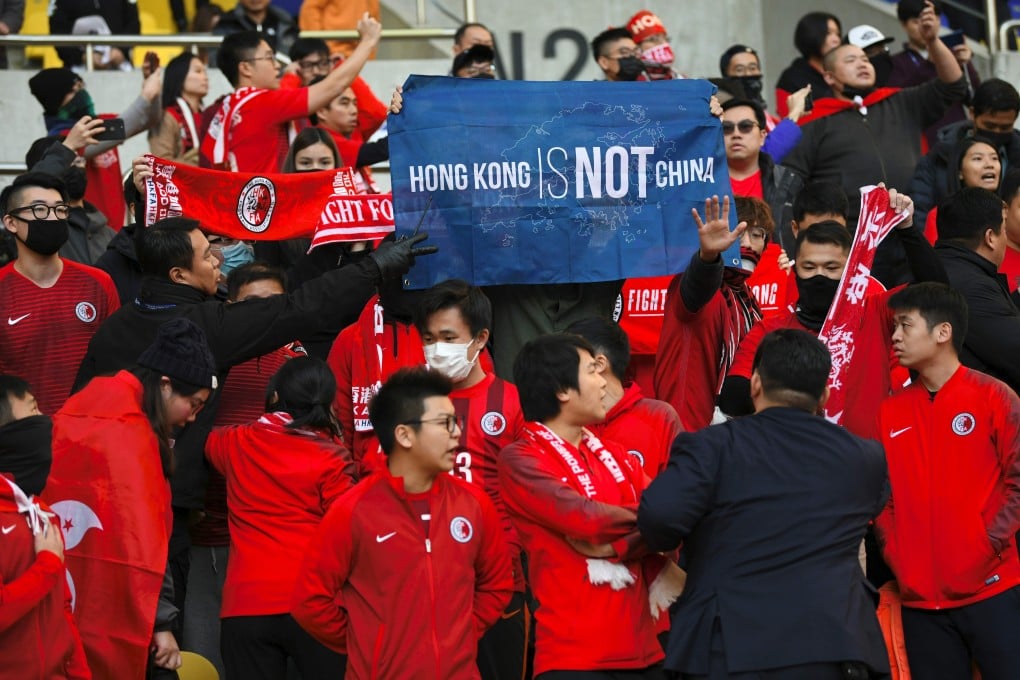 Hong Kong supporters hold a banner reading “Hong Kong is not China" as security members try to take it away match between Hong Kong and China in Busan. Photo: AFP
