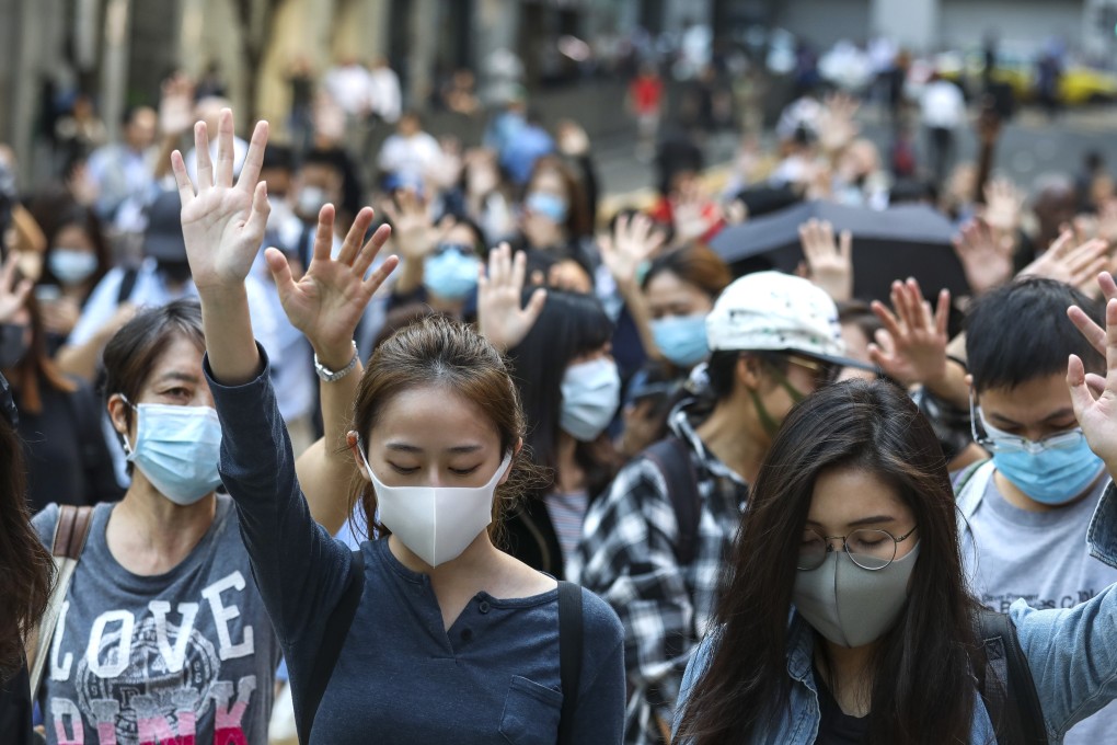 Hong Kong protesters, mostly officer workers, hold up five fingers to symbolise their five demands including universal suffrage, during a lunch-hour rally in Central on November 13. Photo: Nora Tam