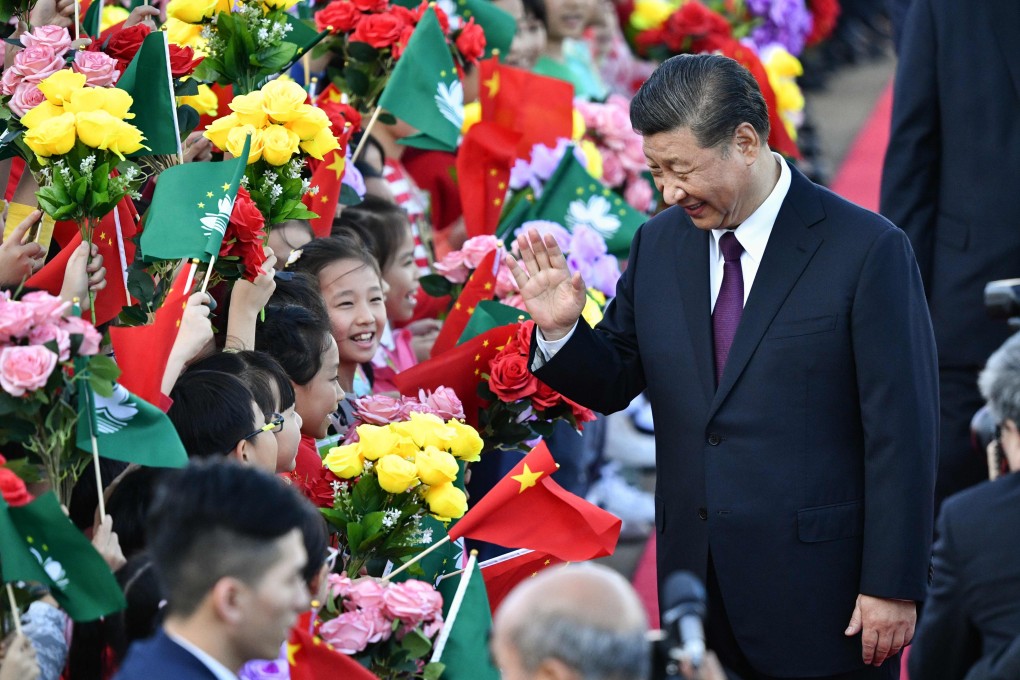 Chinese President Xi Jinping greets children waving the flags upon his arrival in Macau. Photo: AFP