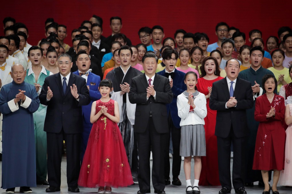President Xi Jinping (centre), outgoing Macau leader Fernando Chui (second left) and incoming chief Ho Iat-seng (second right) join performers onstage during a show in the city. Photo: Reuters