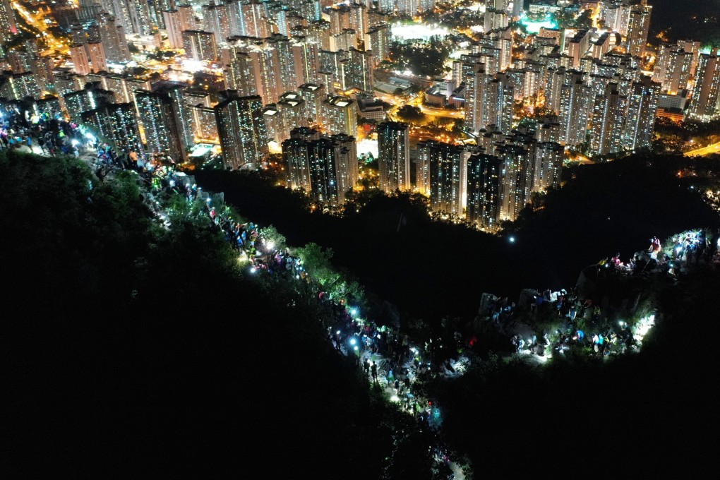 Protesters in Hong Kong shine their mobile phone torches as they form a human chain at the top of Lion Rock Hill, during a rally on August 23. Photo: Winson Wong
