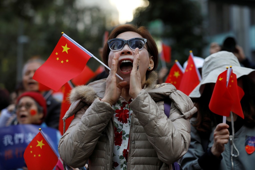 A pro-Beijing demonstrator shouts slogans as she holds a Chinese flag during a rally in Hong Kong on December 7. Photo: Reuters