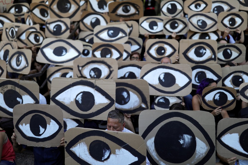 People hold placards during a protest against Chile’s government in Santiago on December 10. Photo: Reuters