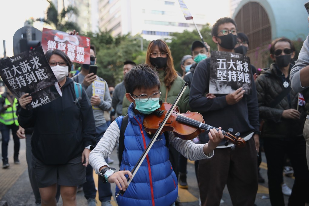 A young violin player joins the march of protesters from Causeway Bay to Central on December 8, the eve of the six-month anniversary of Hong Kong’s civil unrest. Photo: Winson Wong
