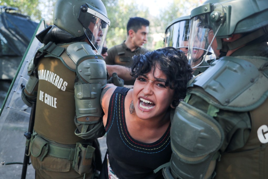 A demonstrator is detained by members of the security forces during a protest against Chile's government in Santiago on December 17. Since the protests began in October, at least 26 people have been killed, several thousand injured and over 25,000 arrested. Photo: Reuters