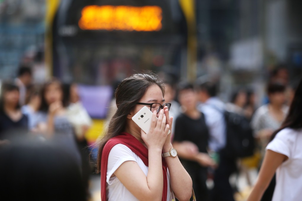 A woman covers up her nose at a crossing in Causeway Bay. Diesel goods vehicles and buses are the main contributor to roadside pollution in Hong Kong. Photo: Sam Tsang