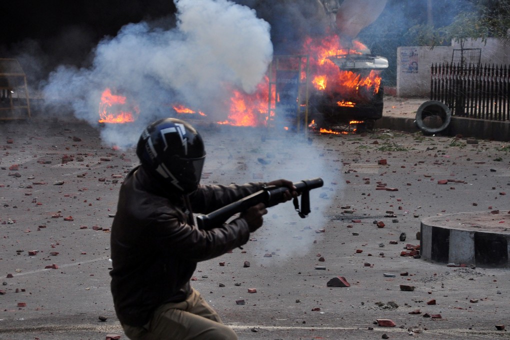 A policeman fires a tear gas shell at demonstrators in Lucknow, India, on Thursday. Photo: Reuters