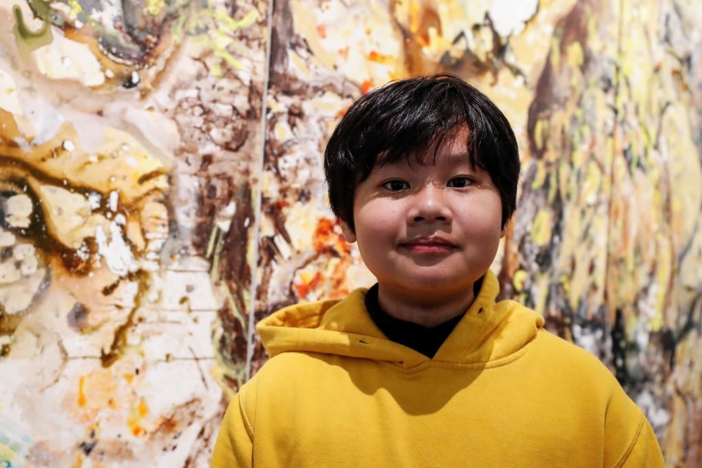 Artist Xeo Chu, 12, poses in front of one of his pieces on Wednesday, before his debut solo exhibition at the Georges Berges Gallery in New York. Photo: Reuters