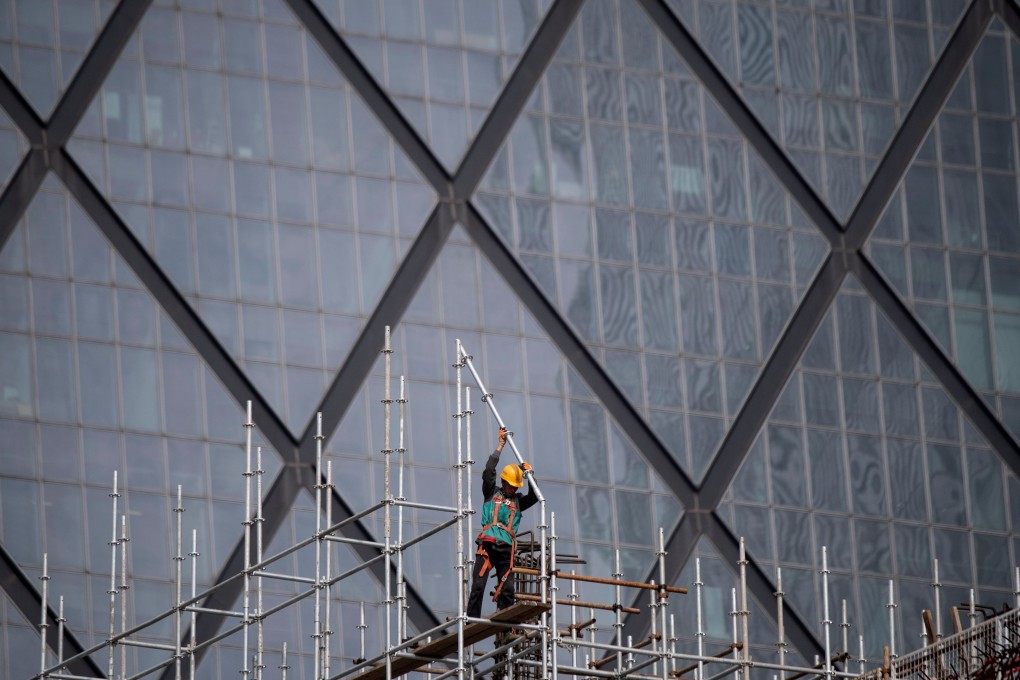 A worker sets up scaffolding at a construction site in Beijing on October 2019. China’s economy expanded at its slowest rate in nearly three decades in the third quarter. Photo: AFP