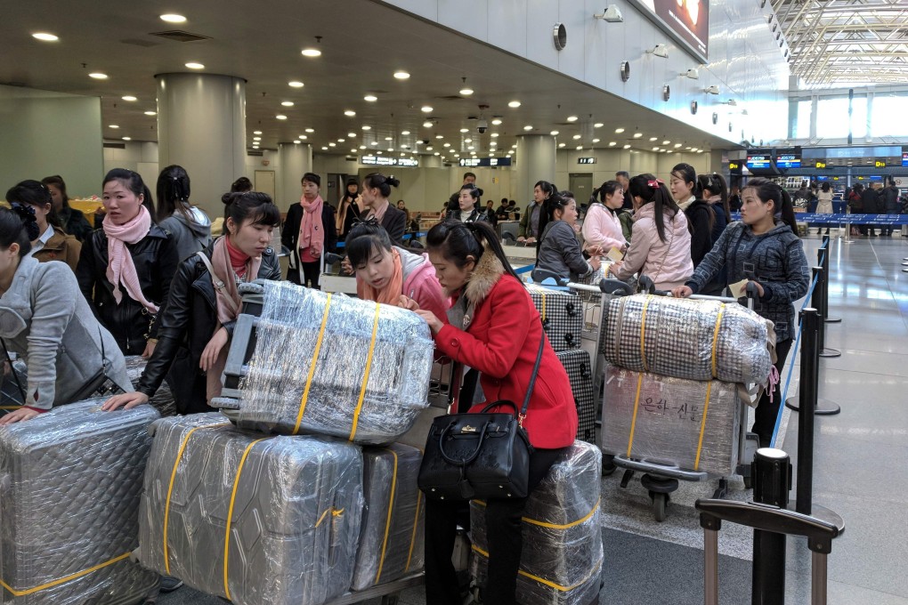 North Korean workers queue for a flight to Pyongyang at an airport in Beijing in March. Photo: AFP