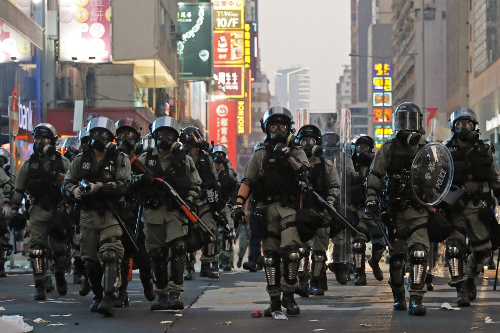 Riot police move toward anti-government protesters occupying a road in Hong Kong. Photo: AP