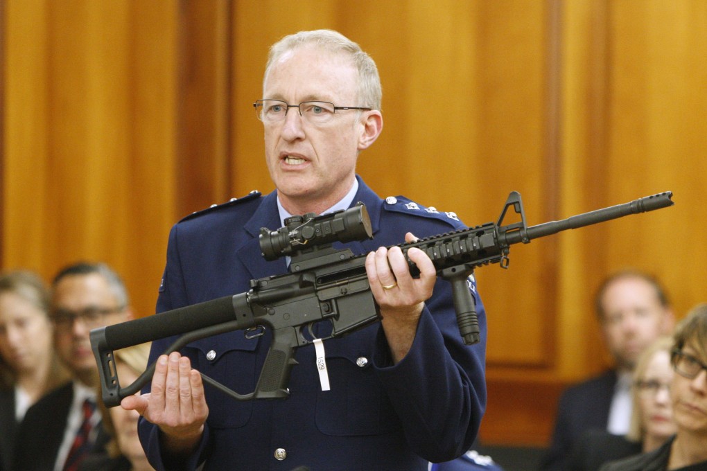 Police acting superintendent Mike McIlraith shows New Zealand lawmakers an assault rifle similar to one of the weapons used by the gunman in the Christchurch massacre. Photo: AP