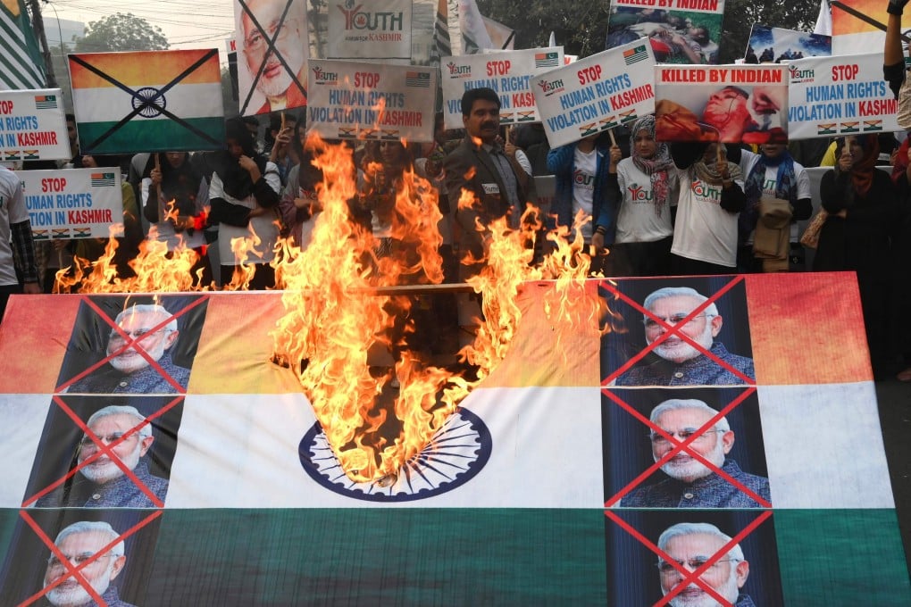 Activists of the Youth Forum for Kashmir burn an Indian flag with pictures of Indian Prime Minister Narendra Modi. Photo: AFP
