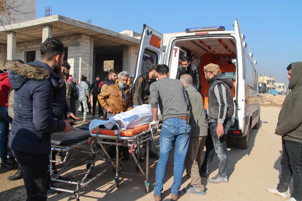 Syrian men transfer a victim to an ambulance following a reported Syrian air strike in the town of Saraqib. Photo: AFP
