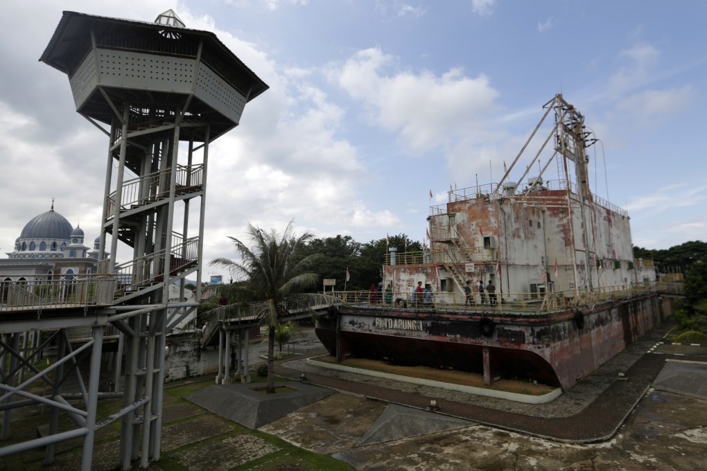 Visitors walk on the power plant boat that was beached during the 2004 Indian Ocean earthquake and tsunami in Banda Aceh. Photo: EPA