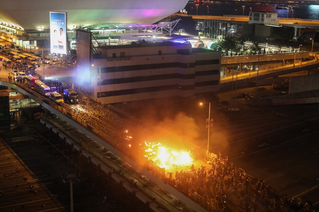 Fire erupts as pro-democracy protesters clash with police on a bridge outside the Hong Kong Polytechnic University in Hong Kong in mid-November. Photo: EPA-EFE