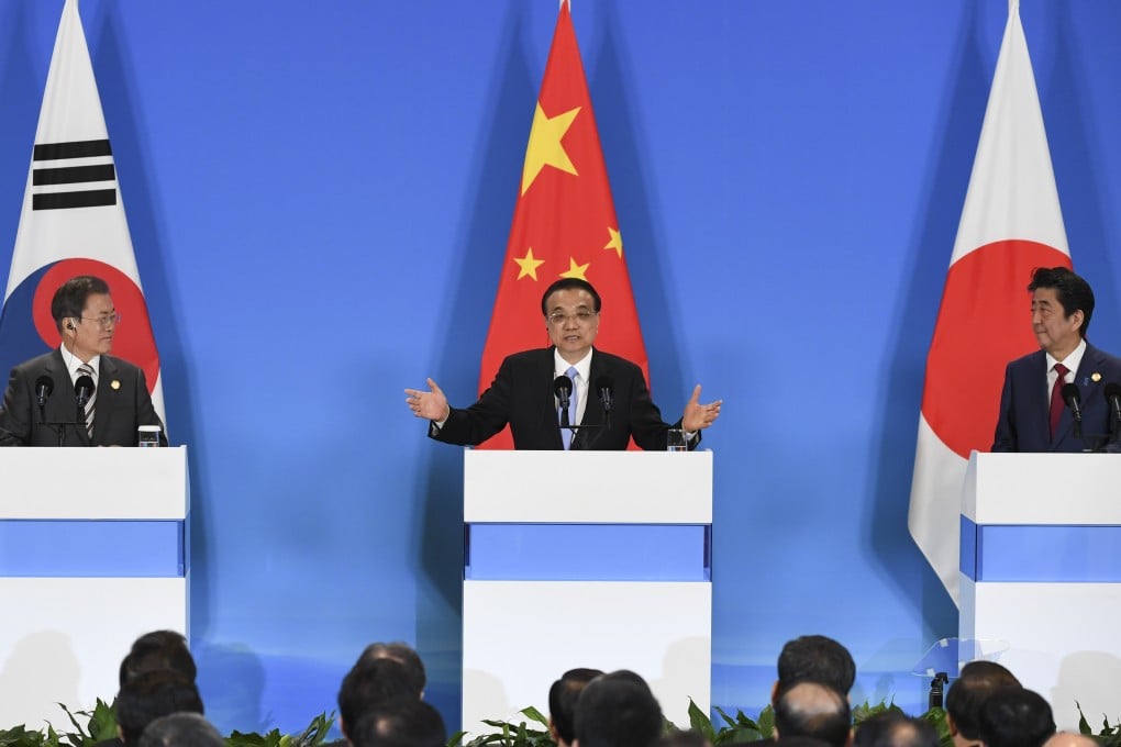Li Keqiang, flanked by Moon Jae-in (left) and Shinzo Abe, speaks at a joint press conference on Tuesday during the summit in Chengdu. Photo: AP