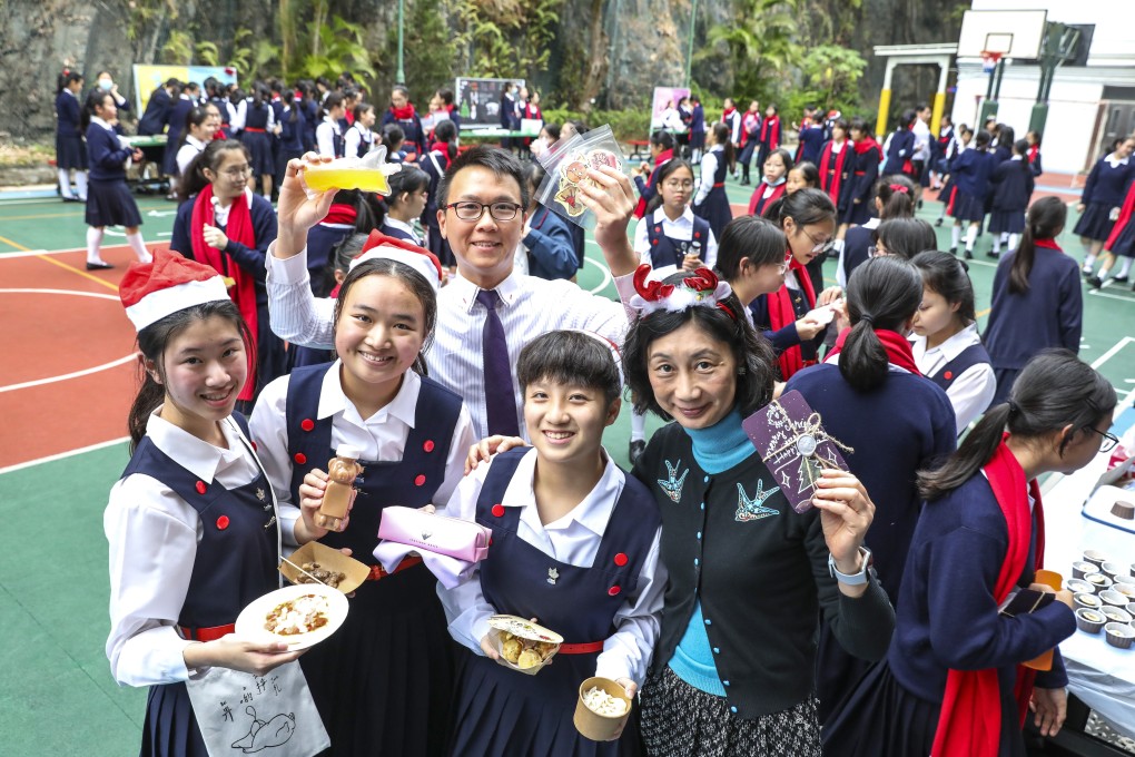 Students at St Clare’s Girls’ School, Natalie Chan, Kelly Lam, and Cody Chu, alongside student activity and leadership coordinator Martin Ma Tin-chun, and vice-principal Paula Wong, display some of the items sold at the fun fair. Photo: Nora Tam