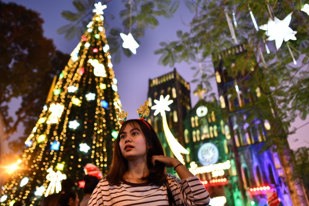 A woman walks past St Joseph's cathedral in the old quarters of Hanoi on Christmas Eve. Photo: AFP