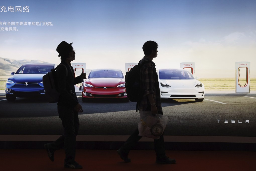 Attendees walks past an advertisement for electric cars from Tesla, which has qualified for a government subsidy of as much as about US$3,600 per vehicle for its China-built Model 3. Photo: AP