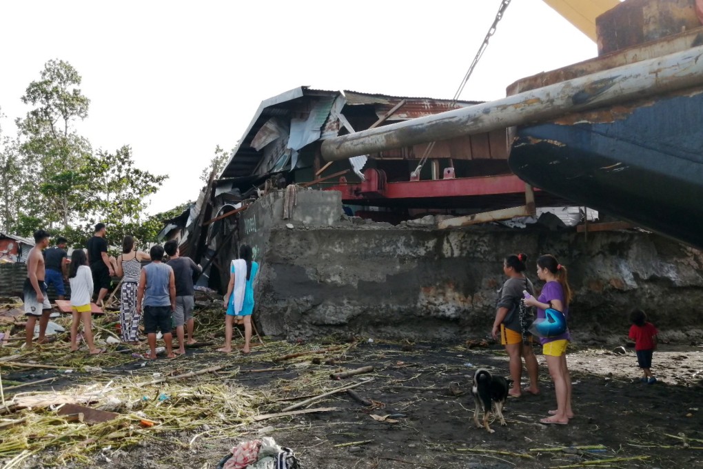 Villagers walk around a cargo ship washed ashore on Christmas Day in the typhoon-hit city of Ormoc, Leyte province in the central Philippines. Photo: EPA-EFE