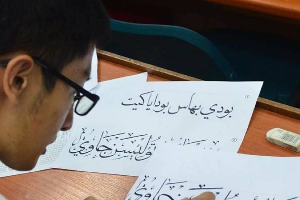 A Malaysian student writes using the khat script. Photo: Ahemed Rafeeq | Twitter