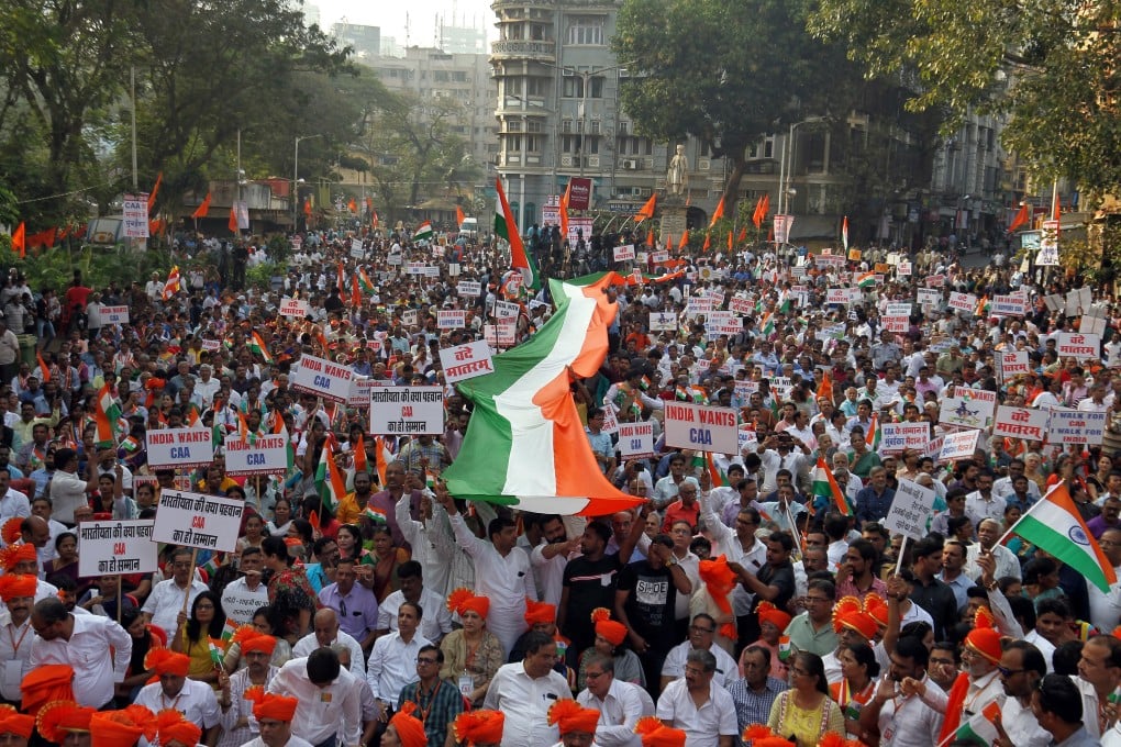 Supporters of India's ruling Bharatiya Janata Party (BJP) carry national flags during a rally in Mumbai in support of a new citizenship law. Photo: Reuters