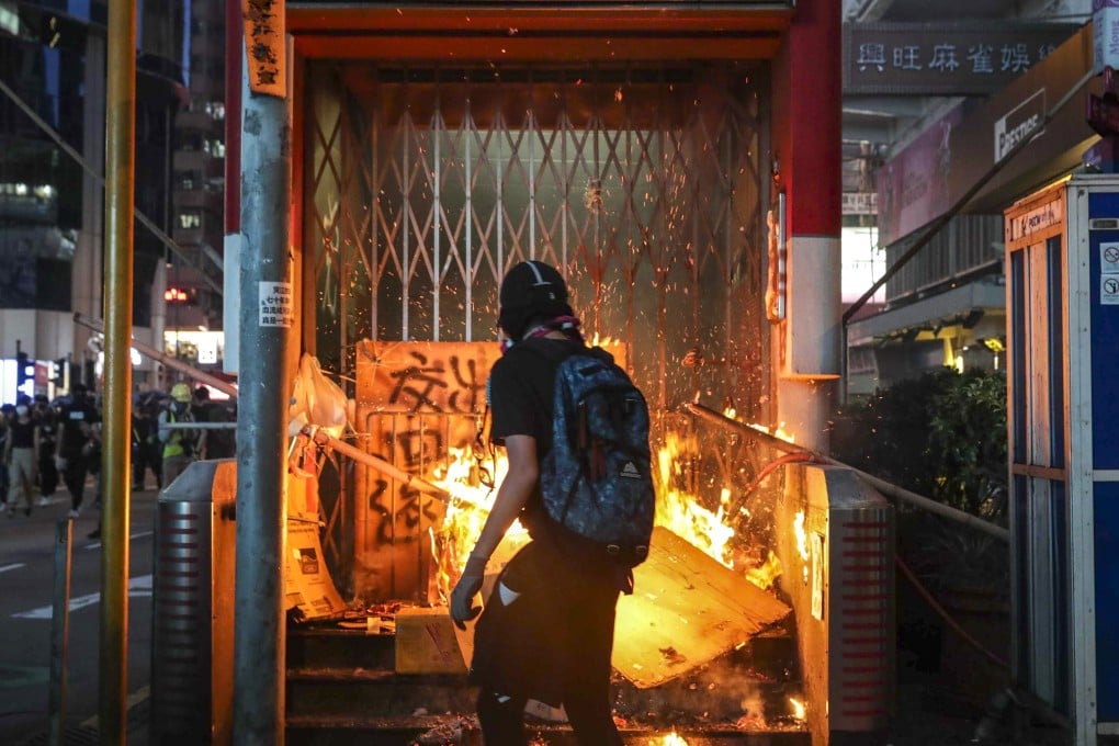 An anti-government protester sets fire to an entrance of Mong Kok MTR station during an illegal rally in October. Photo: Edmond So