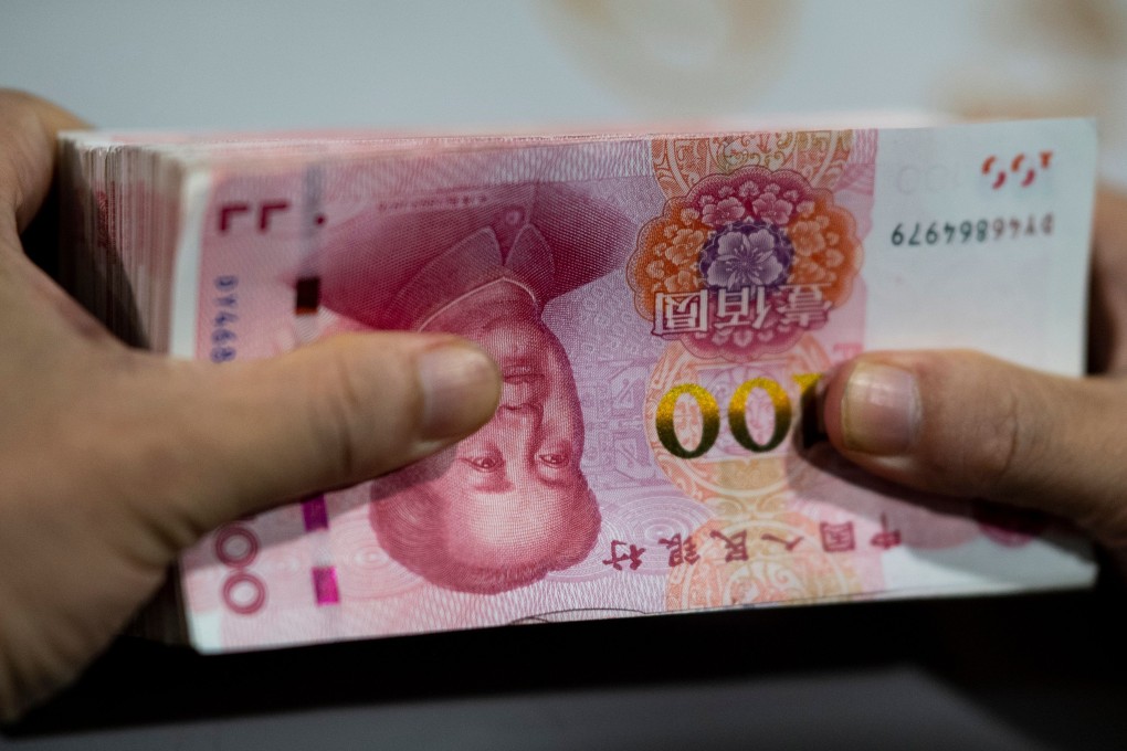 A bank employee counts out 100-yuan notes in Shanghai. China and the US pushed global debt to a record US$251 trillion in the first half of 2019. Photo: AFP