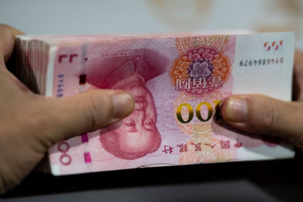 A bank employee counts out 100-yuan notes in Shanghai. China and the US pushed global debt to a record US$251 trillion in the first half of 2019. Photo: AFP