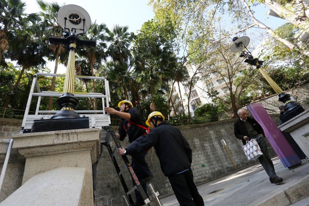 Workers from Towngas complete the reinstallation of street lamps on Duddell Street, Central. Photo: Jonathan Wong