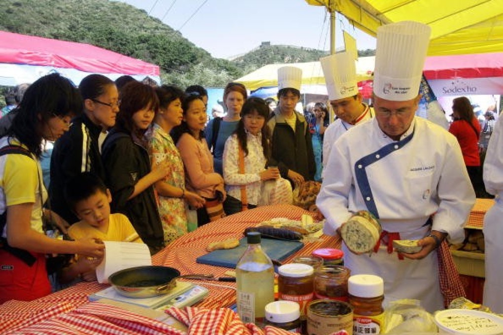 Chinese people wait to sample varieties of French cheese in Beijing. Photo: Frederic J. Brown/AFP via Getty Images