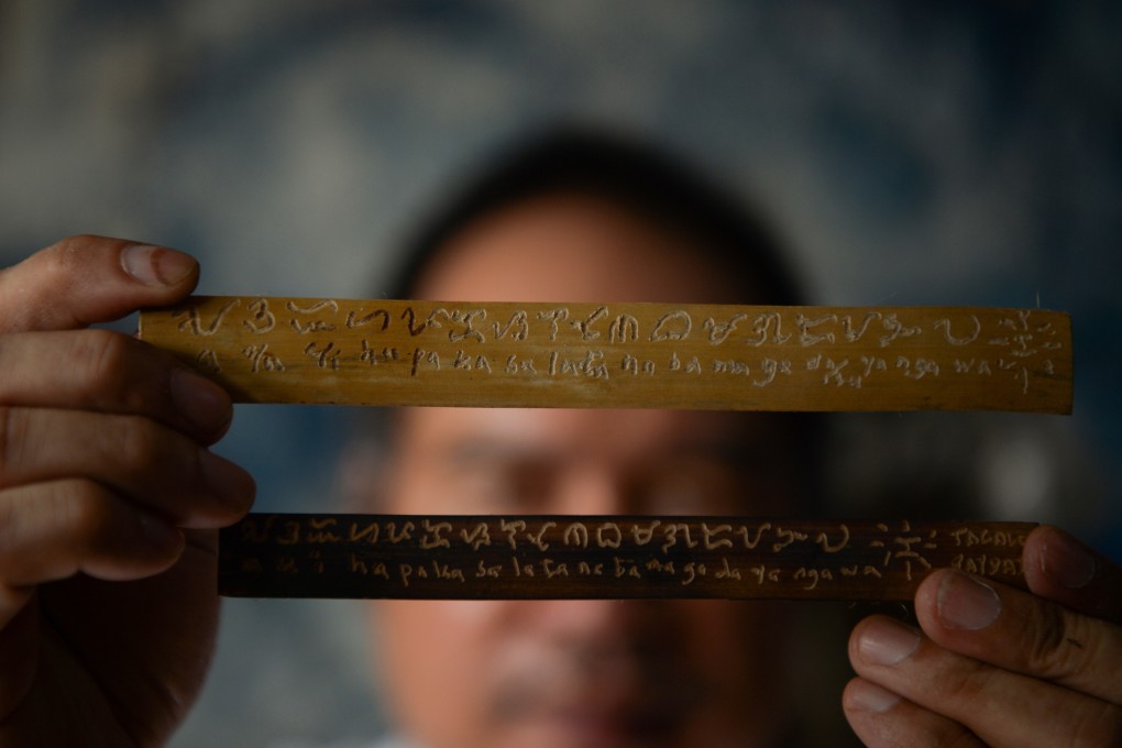 Cultural advocate Leo Emmanuel Castro holds pieces of bamboo inscribed with indigenous Baybayin script at his shop in Manila, in the Philippines. Photo: AFP
