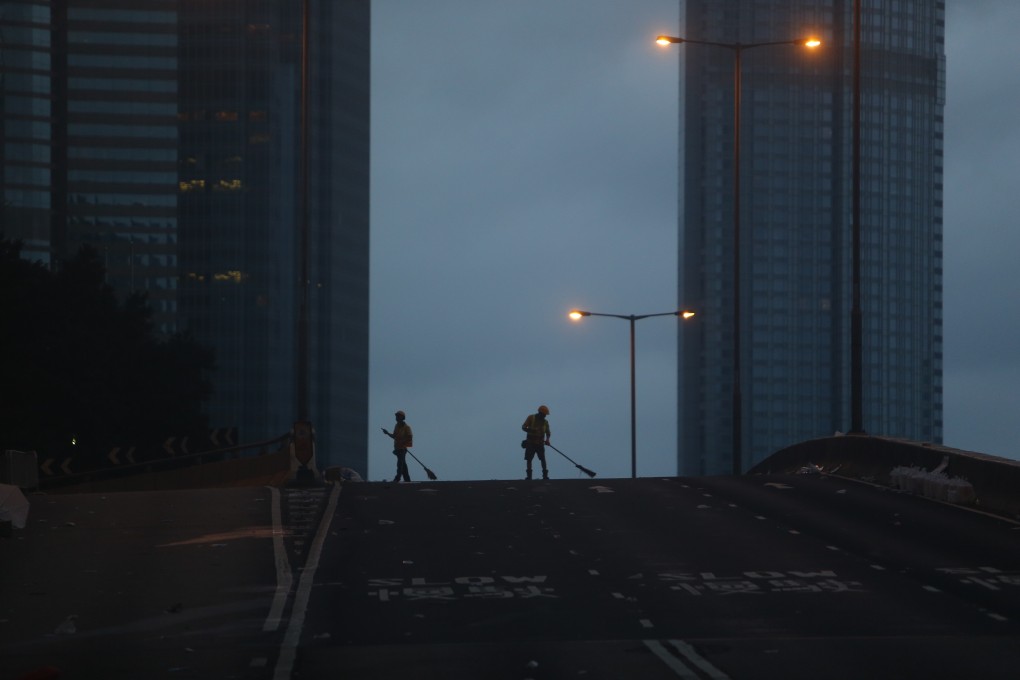 Workers sweep up litter left behind on the Harcourt Road flyover in Admiralty on June 13, a day after anti-extradition bill protests took place outside the Legislative Council. Photo: Winson Wong