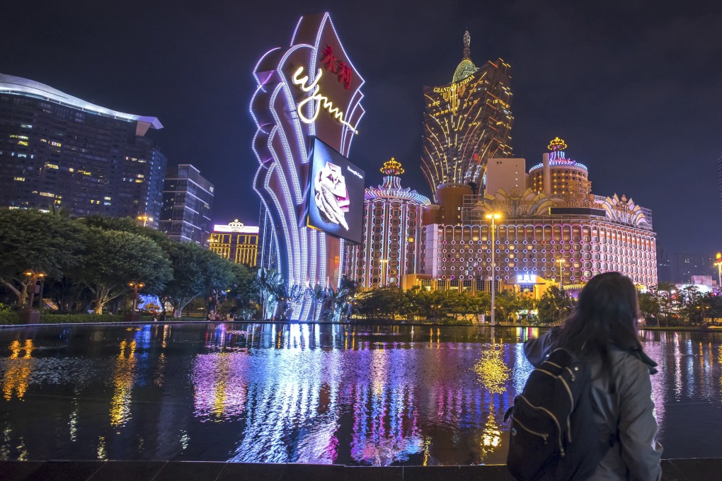A pedestrian walks past signages for major casino resorts in Macau. The city was in a security lockdown ahead of President Xi Jinping visit in December 2019. Photo: Bloomberg
