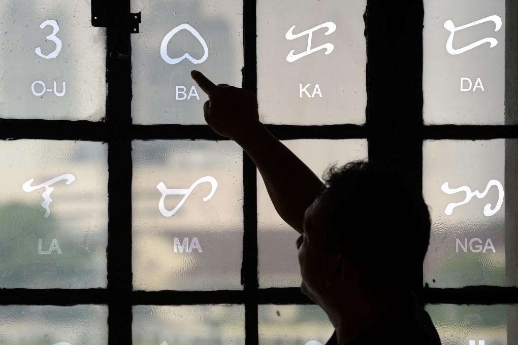 Baybayin characters etched on a glass window at the National Museum in Manila. The pre-colonial script is undergoing a revival of sorts, and an enthusiast’s card game is helping spread the word about it. Photo: Ted Aljibe/AFP