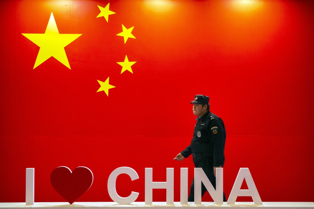 A security officer walks past a display with the Chinese flag at a technology expo in Beijing on October 31, 2019. The US-China trade war has given expression to many global anxieties about China’s rise. Photo: AP