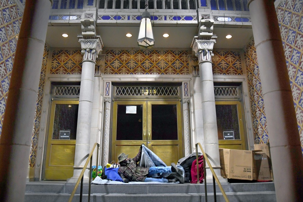 A homeless man in Washington D.C. beds down for the night opposite Franklin Square park on the steps of the Sphinx Club at Almas Temple. Donald Trump’s cuts to social spending, while raising the defence budget and offering tax cuts that benefit the rich, have contributed to increased inequality. Photo: Washington Post