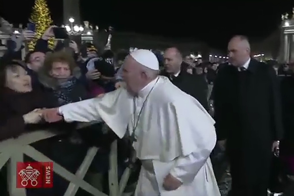 A frame grab taken from a handout video shows a lady grabbing at Pope Francis’ hands in Vatican City. Photo: AFP