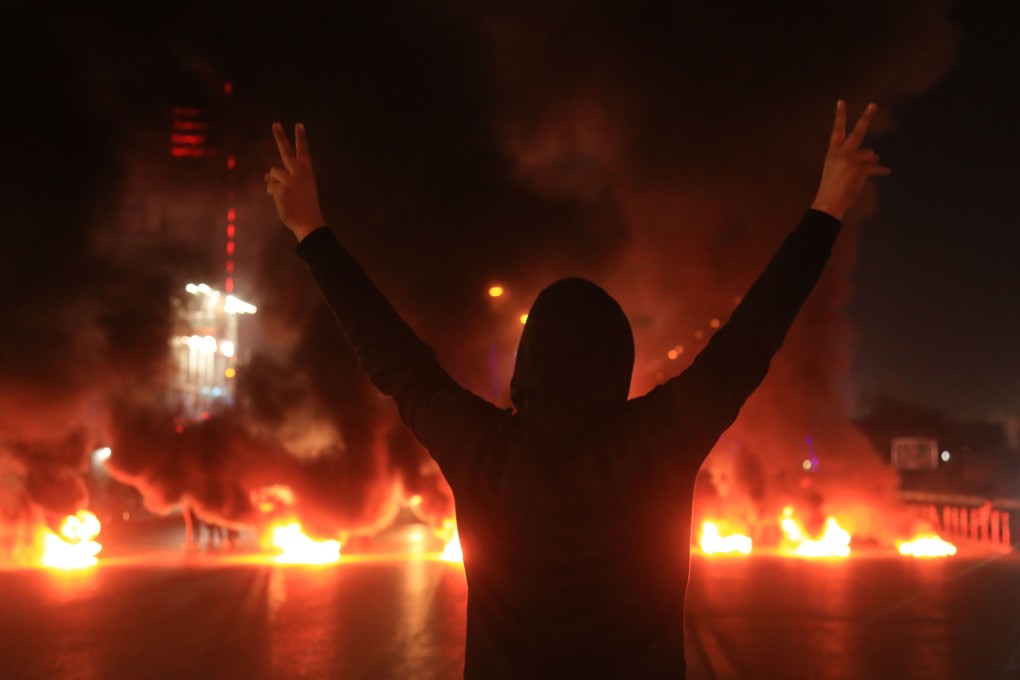 An Iraqi demonstrator gestures as tyres burn during a protest last month in Iraq’s shrine city of Karbala, south of the capital Baghdad. Photo: AFP