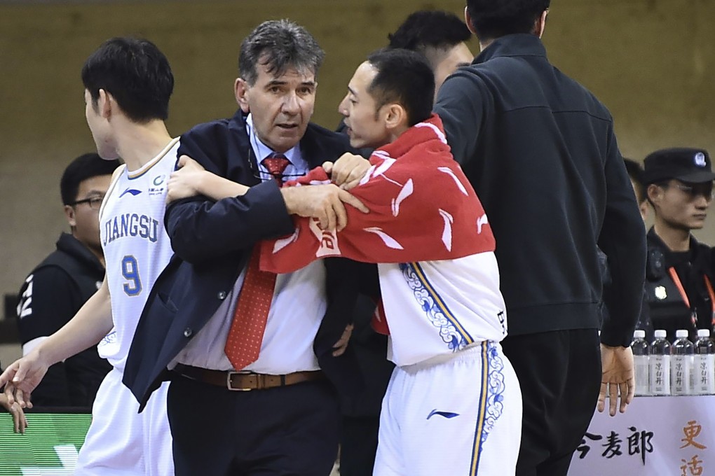 Jiangsu Dragons coach Memi Becirovic is restrained by his player, Shi Hongfei, during the melee earlier this week. Photos: AP