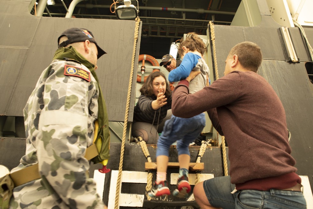 Evacuees from Mallacoota, Victoria State, boarding the Royal Australian Navy MV Sycamore, at sea, during bush fire relief efforts. Photo: EPA-EFE