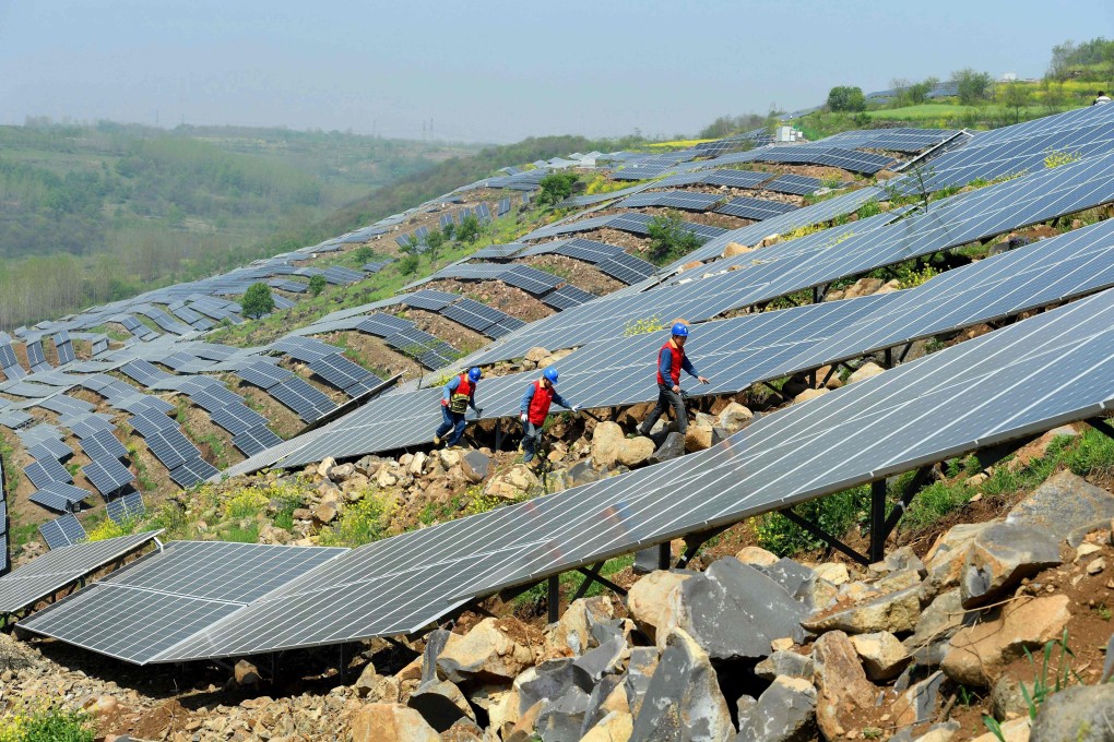 Chinese workers check solar panels on a hillside in Anhui province. China is encouraging a transition towards a green economy and financial system, rather than the more diffuse approaches taken in the US, Europe and Japan. Photo: AFP