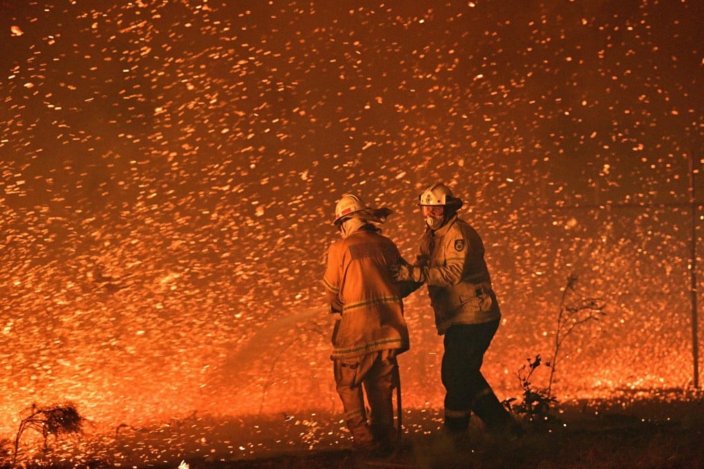 Firefighters struggle to secure houses from bushfires near the town of Nowra in the Australian state of New South Wales. Photo: AFP