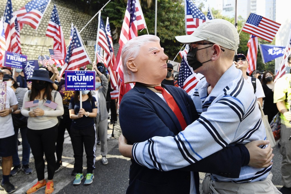 A masked protester embraces a man wearing a Donald Trump mask at a pro-US rally on December 1 in Hong Kong, after US President Donald Trump signed the Hong Kong Human Rights and Democracy Act. Photo: Kyodo